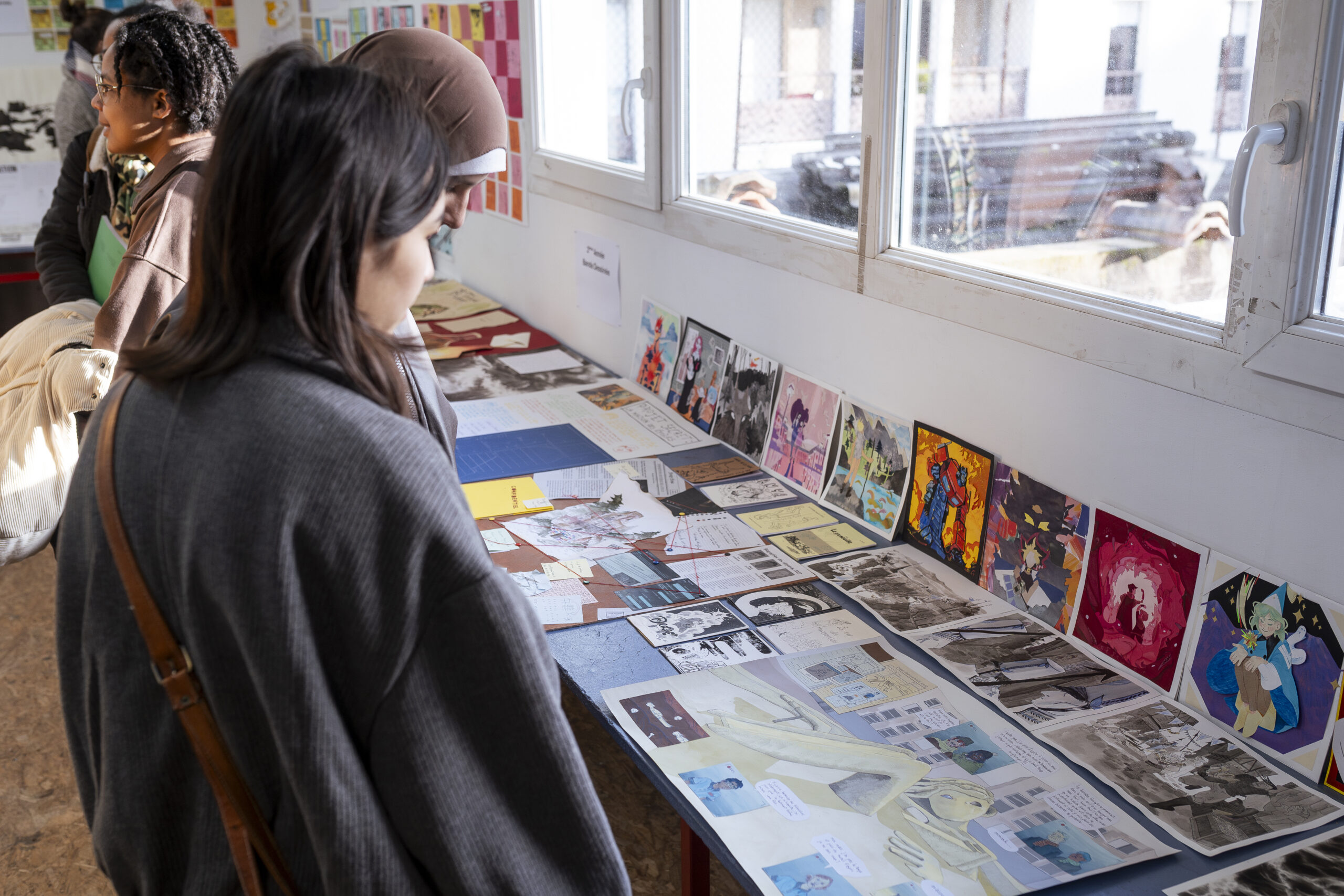 personne participant à une soirée portes ouvertes regardant travaux et dessins